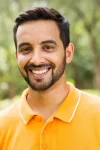 young-indian-man-happy-outdoors-looking-camera-39595562